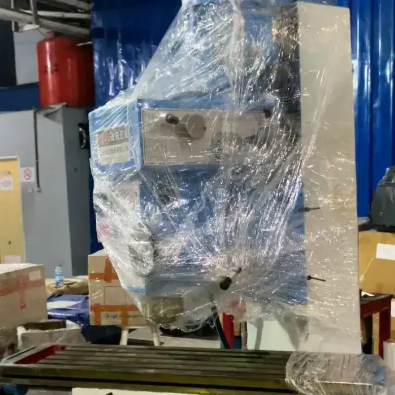Mesin industri dibungkus plastik wrap sebagai contoh persiapan kirim mesin industri agar lebih aman.