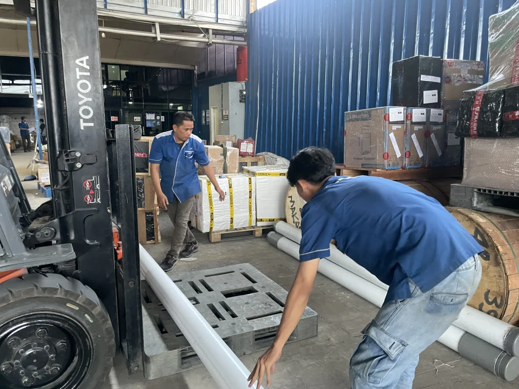 Jasa kirim pipa HDPE dengan proses handling dan loading di gudang Papandayan Cargo menggunakan forklift sebelum pengiriman.